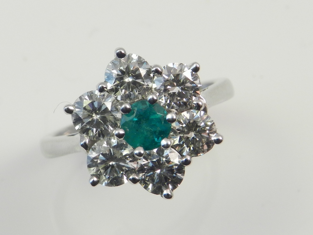 An 18ct white gold emerald and diamond ring, with six brilliant cut diamonds of approx. 1.9cts