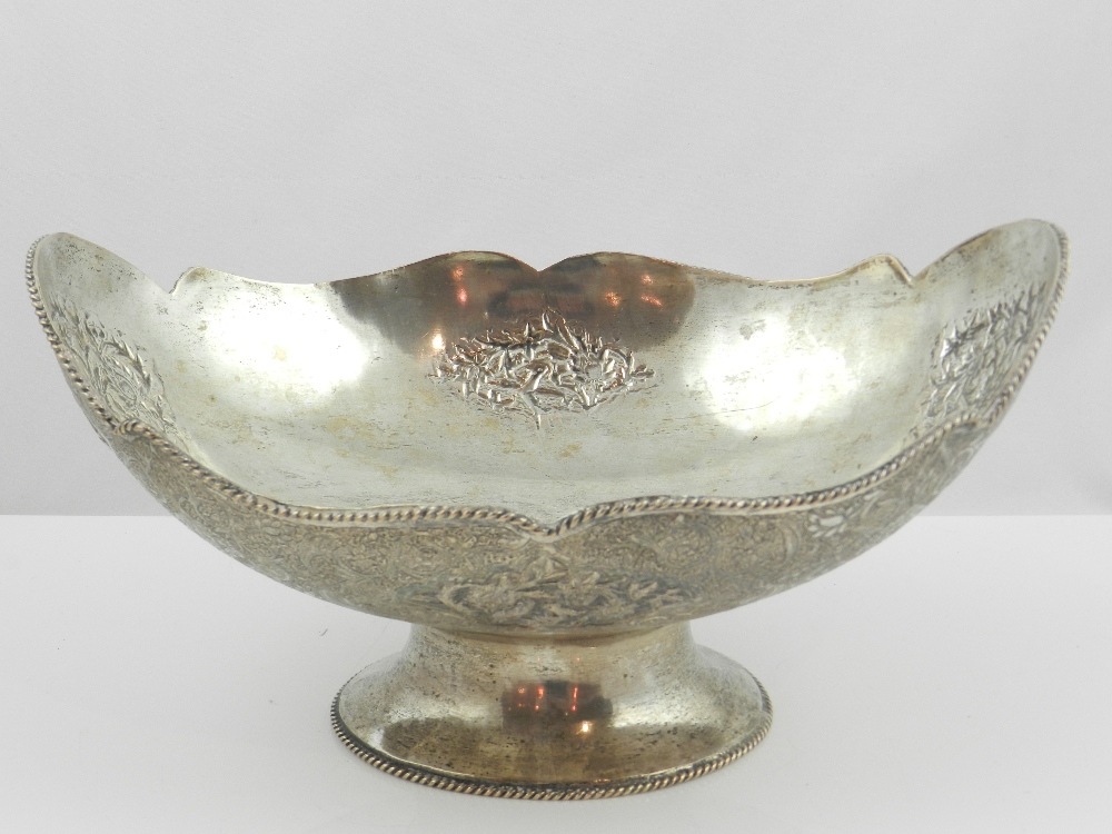 A Persian white metal oval bowl, with applied waived ropetwist border, the sides engraved and chased