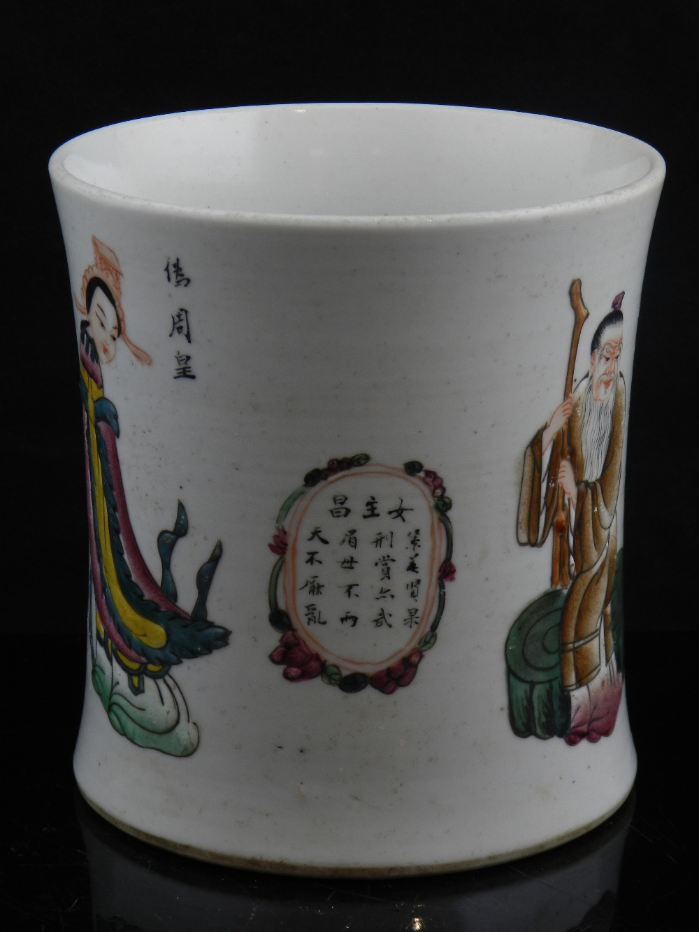 A Chinese famille rose cylindrical brush pot, carved with figures and characters.