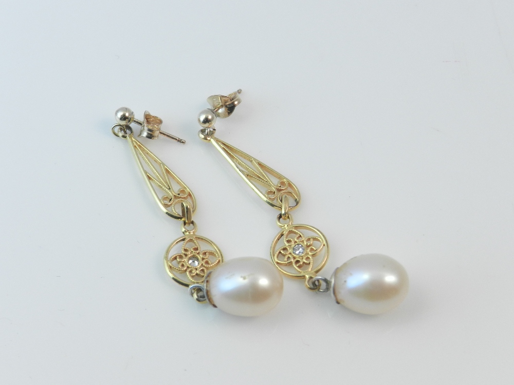 A pair of yellow metal diamond and pearl drop earrings in the Belle Epoque style.