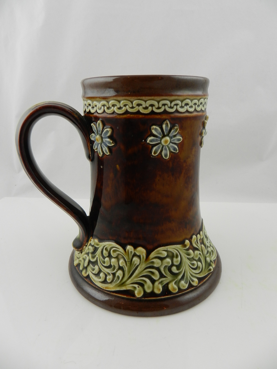 A Doulton Lambeth stoneware mug together with a salt glaze porcelain water pot relief decorated with