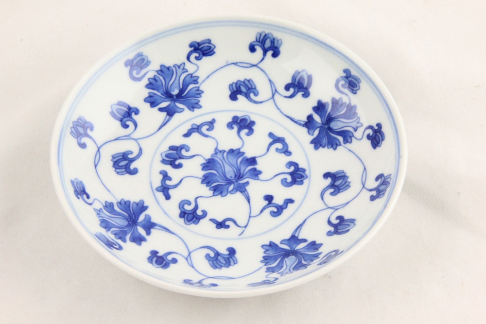 A Chinese blue and white bowl decorated with stylized leaves and flowers, six character marks to the