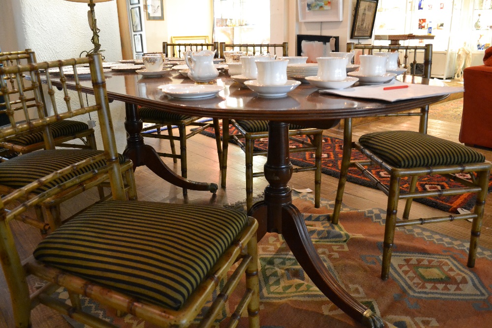 An inlaid mahogany twin pillar dining table with extra leaf.