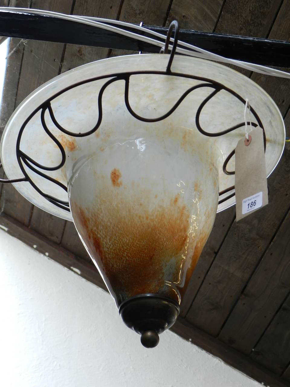 A metal mounted art glass ceiling light of trumpet form