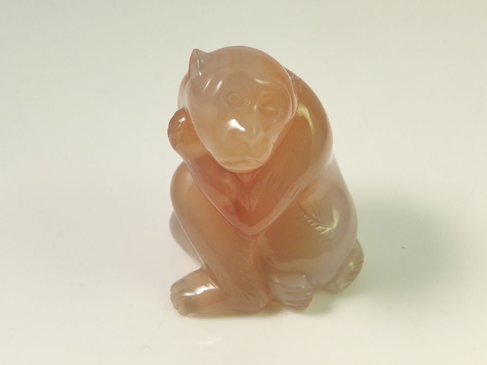 A Chinese carved agate monkey in seated position.