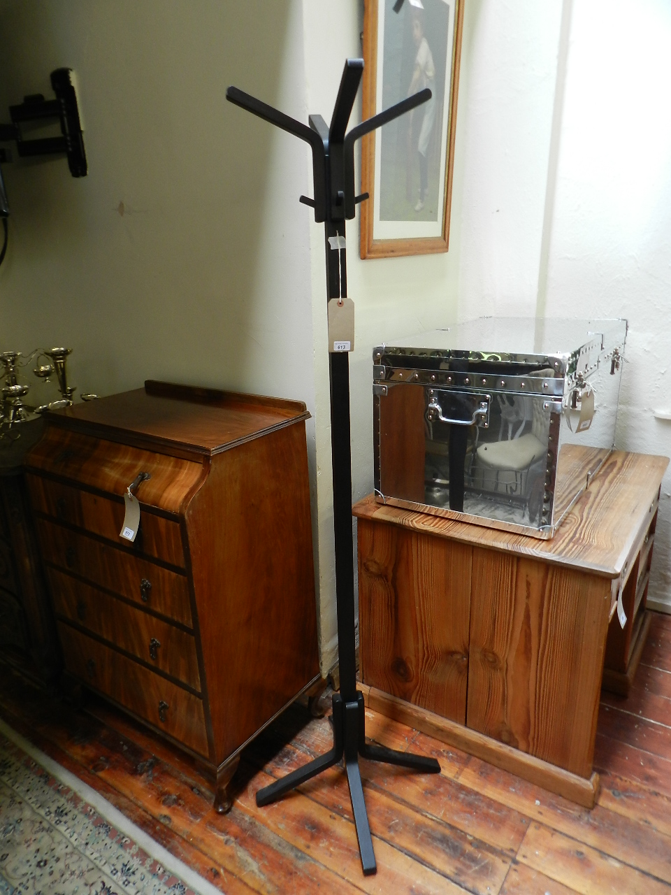 An ebonized wooden pedestal coat and hat stand.