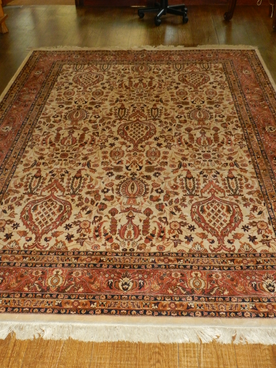 A Tabriz style rug decorated with vase of flower designs on a cream ground contained by border.