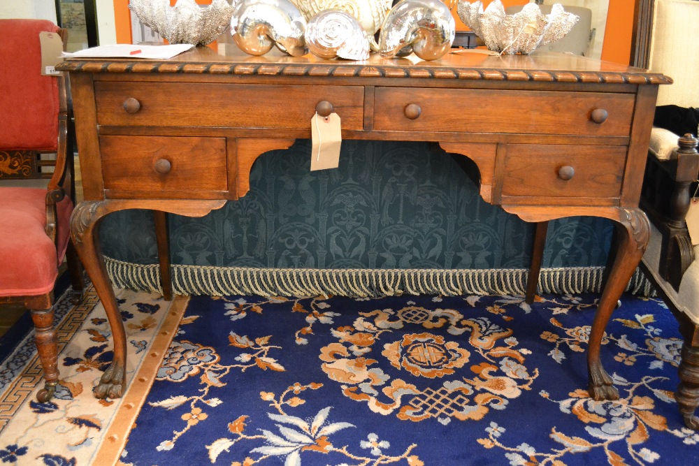 An early 20th century mahogany rectangular desk with heavy gadrooned border having two long