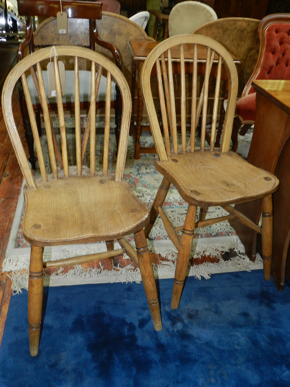 A set of four Elm hoop back kitchen dining chairs with solid seats raised on turned supports.