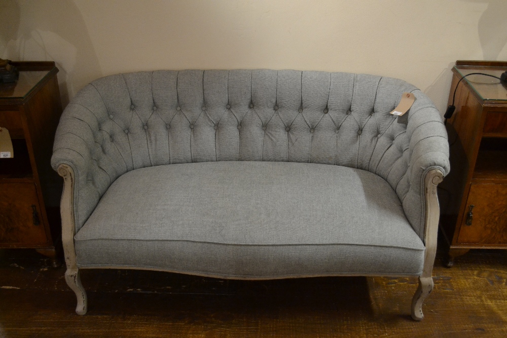 A painted show wood framed two seater sofa button back upholstered in a sky blue linen.
