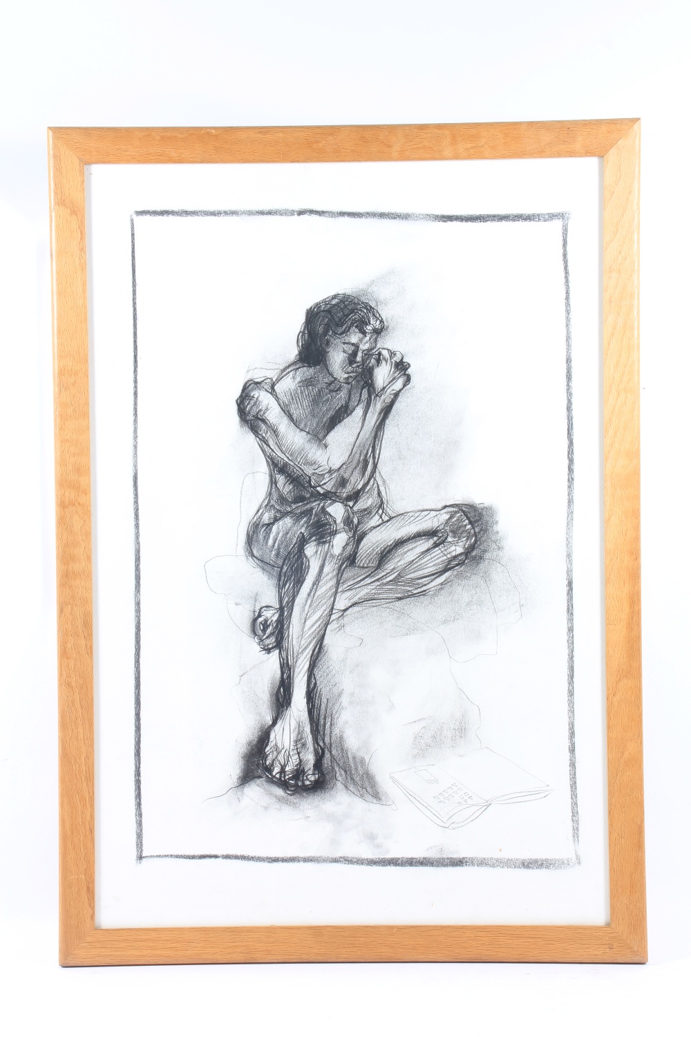A glazed and framed charcoal sketch of a seated nude, 79 x 53 cm.