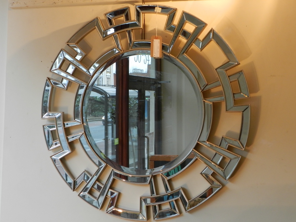 An art deco style beveled glass mirror of circular form.