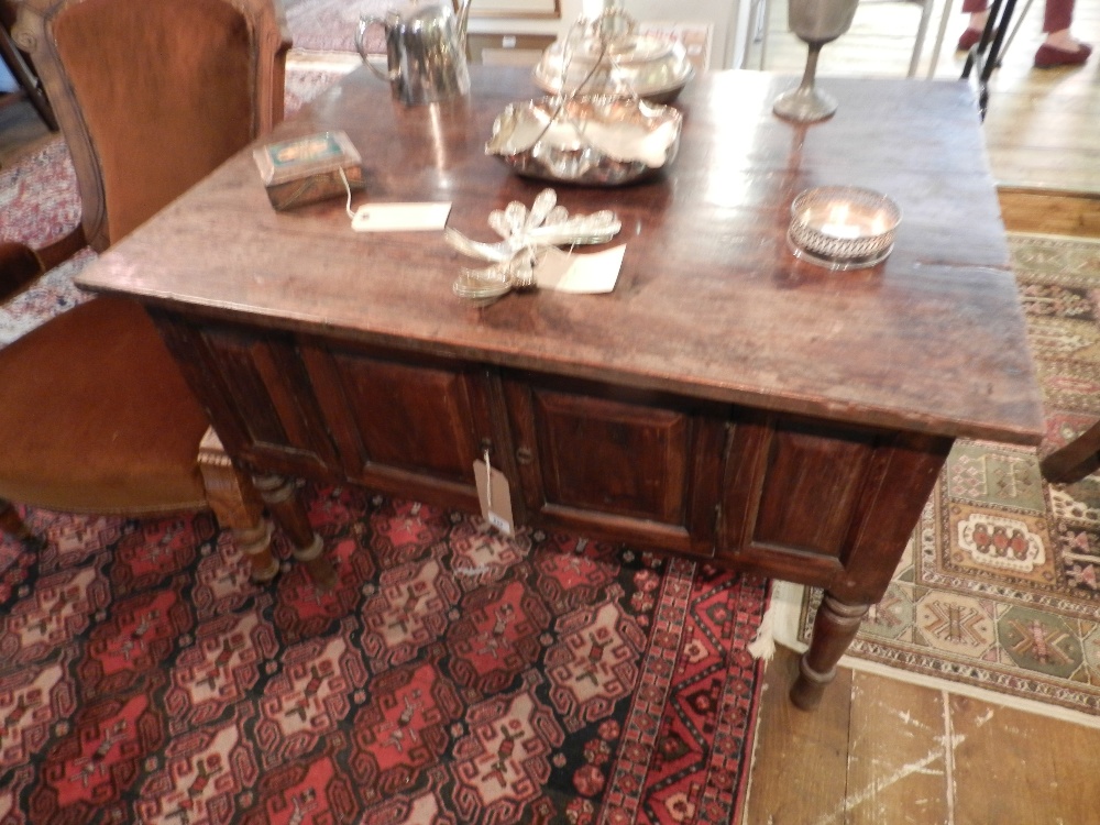 A Dutch teak sideboard of panelled construction on turned legs.