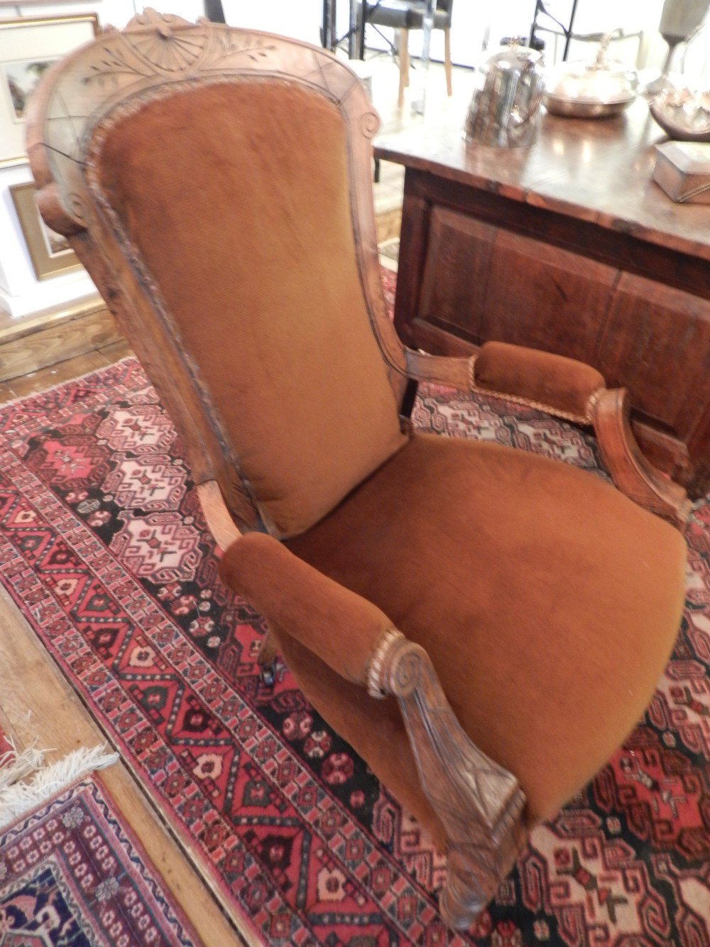 An Edwardian carved walnut framed library chair upholstered in brown cord