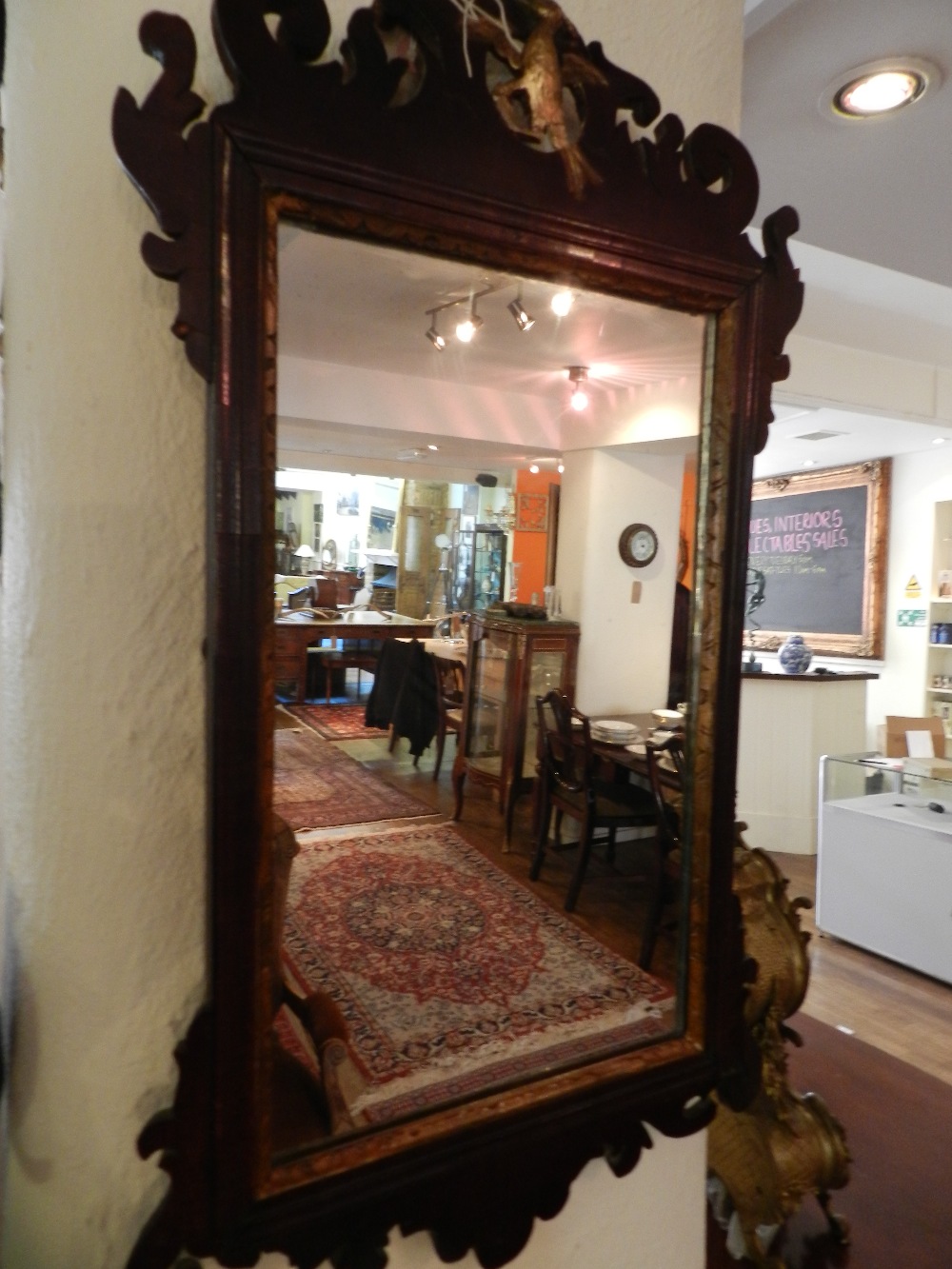 A George III style mahogany framed hall mirror having carved and pierced ho ho bird decoration.
