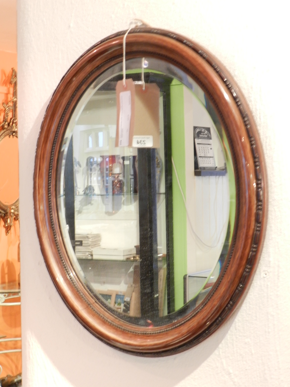 A fruit wood framed oval mirror having a bevelled plate glass