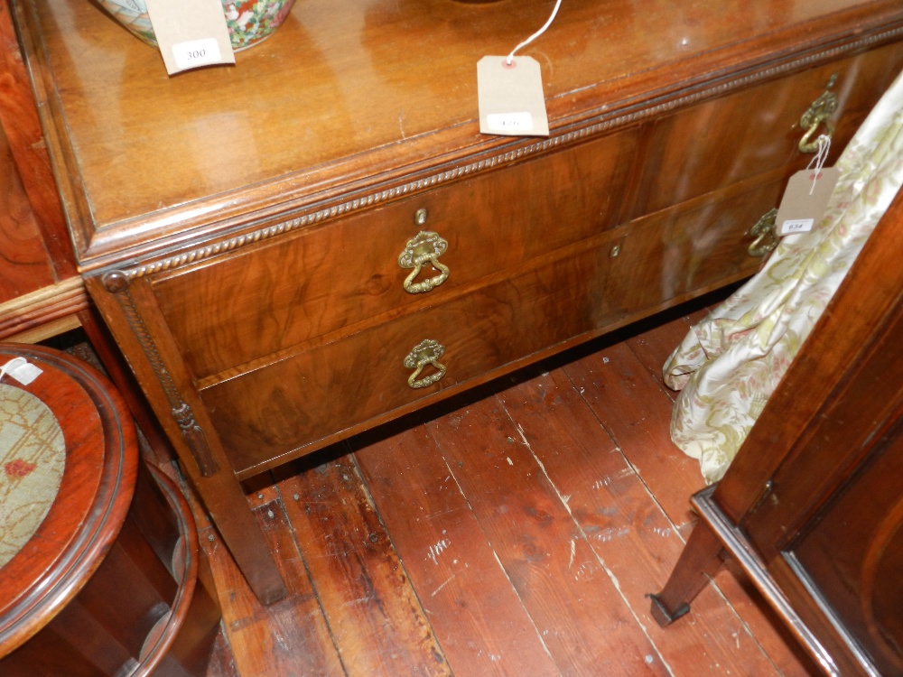 A mahogany dressing chest of three drawers raised on square section supports.