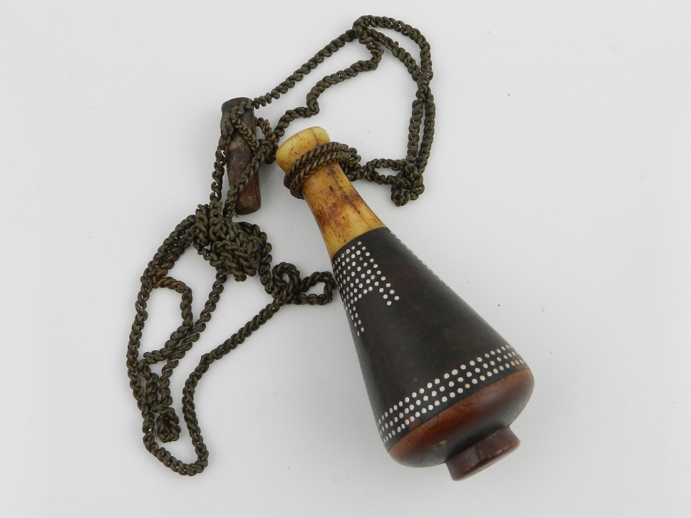 A Tribal antique bone and hardwood portable snuff/oil bottle having geometric silver inlaid design.