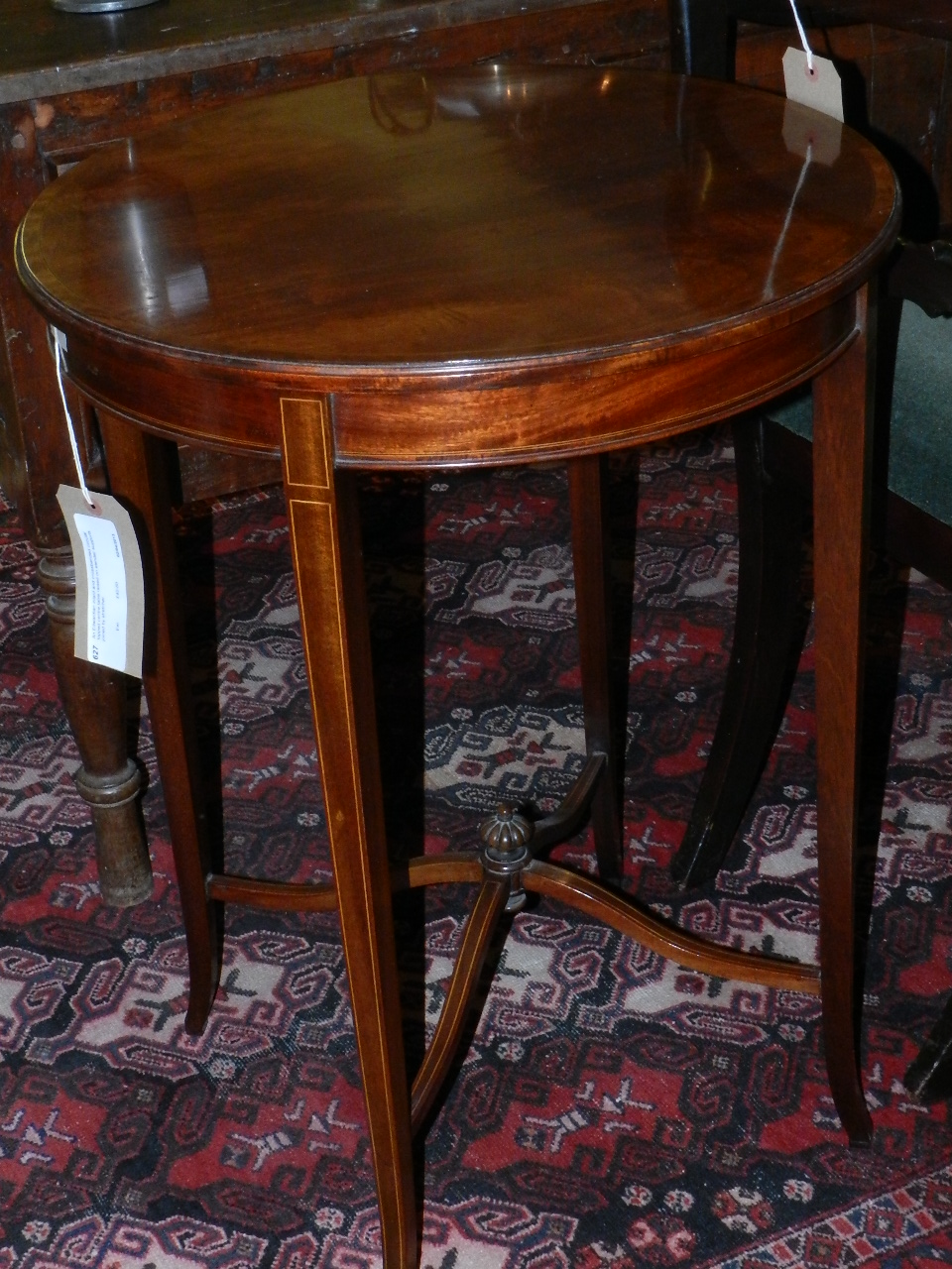 An Edwardian inlaid and crossbanded circular topped centre table raised on slender supports joined