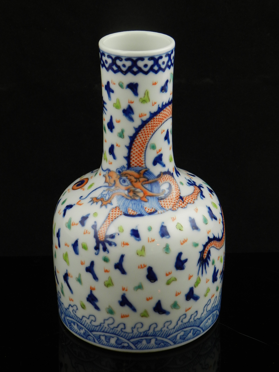 A Chinese porcelain bottle vase decorated with dragons, and stylized waves.