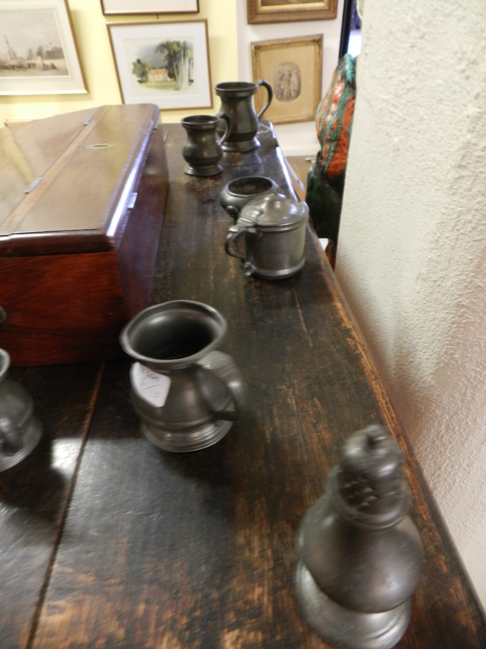 A group of ten items of antique pewter comprising seven jugs quarter gill to gill sizes,a caster,