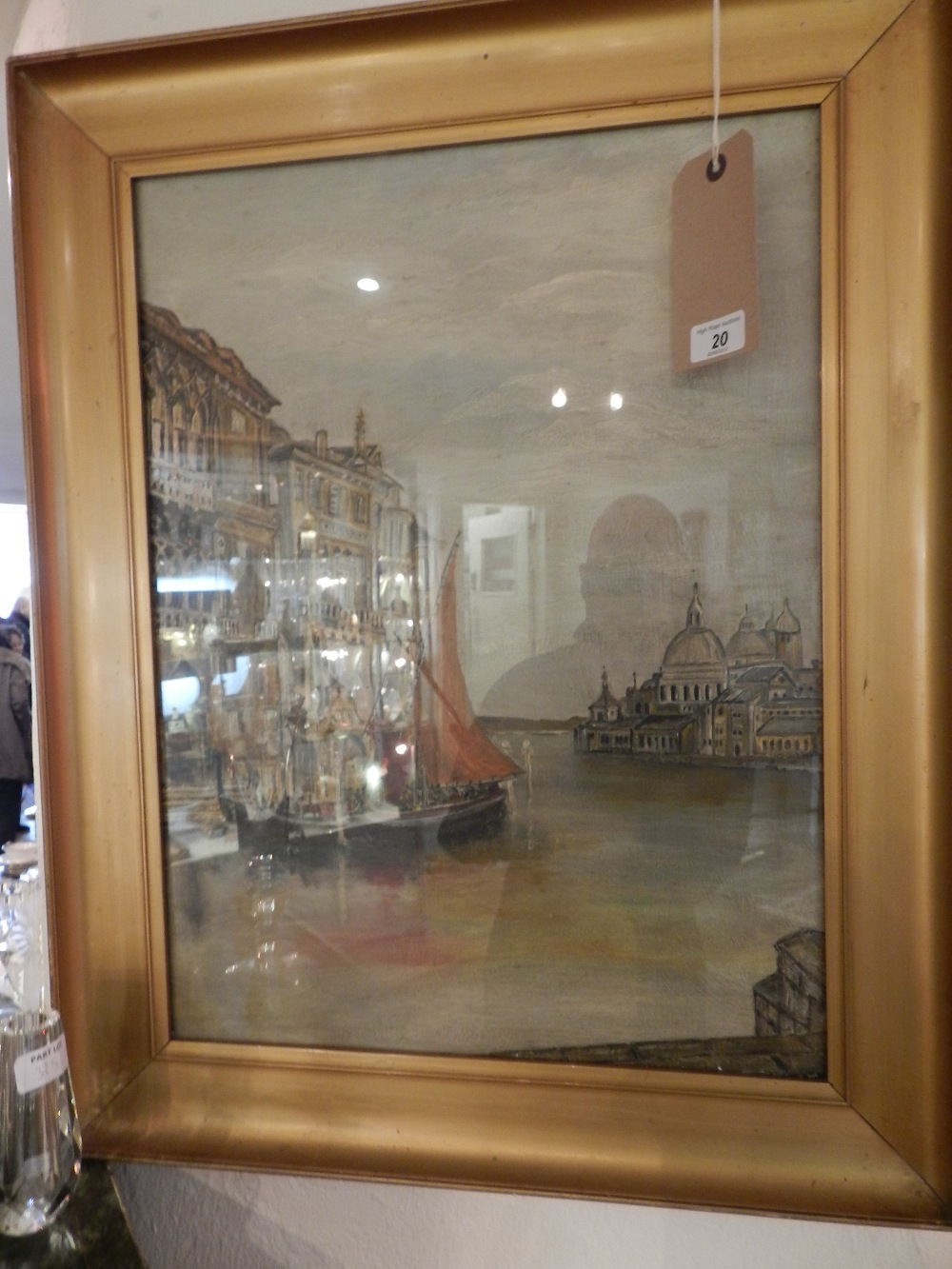 A gilt framed oil on canvas depicting a Venetian scene, with boats on the canal.