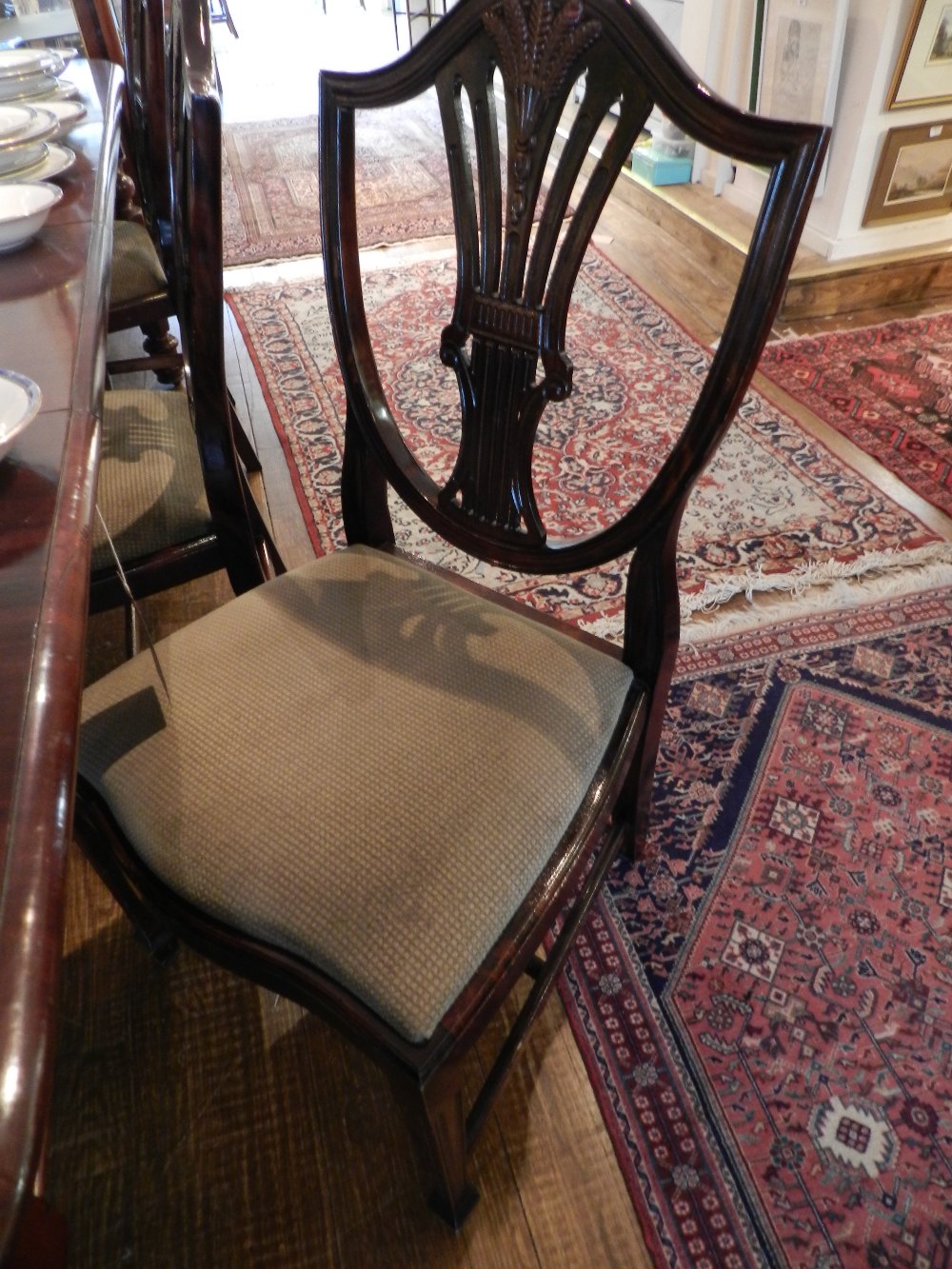 A set of six mahogany shield back dining chairs having wheat sheath carved and pierced back splats