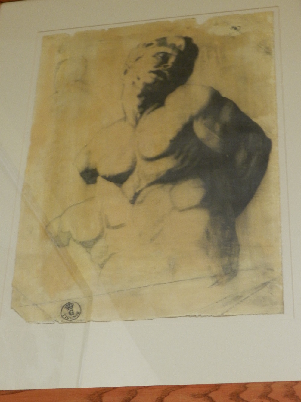 A large framed pencil and charcoal sketch of a male torso stamped in a circle with G Fibenze and a