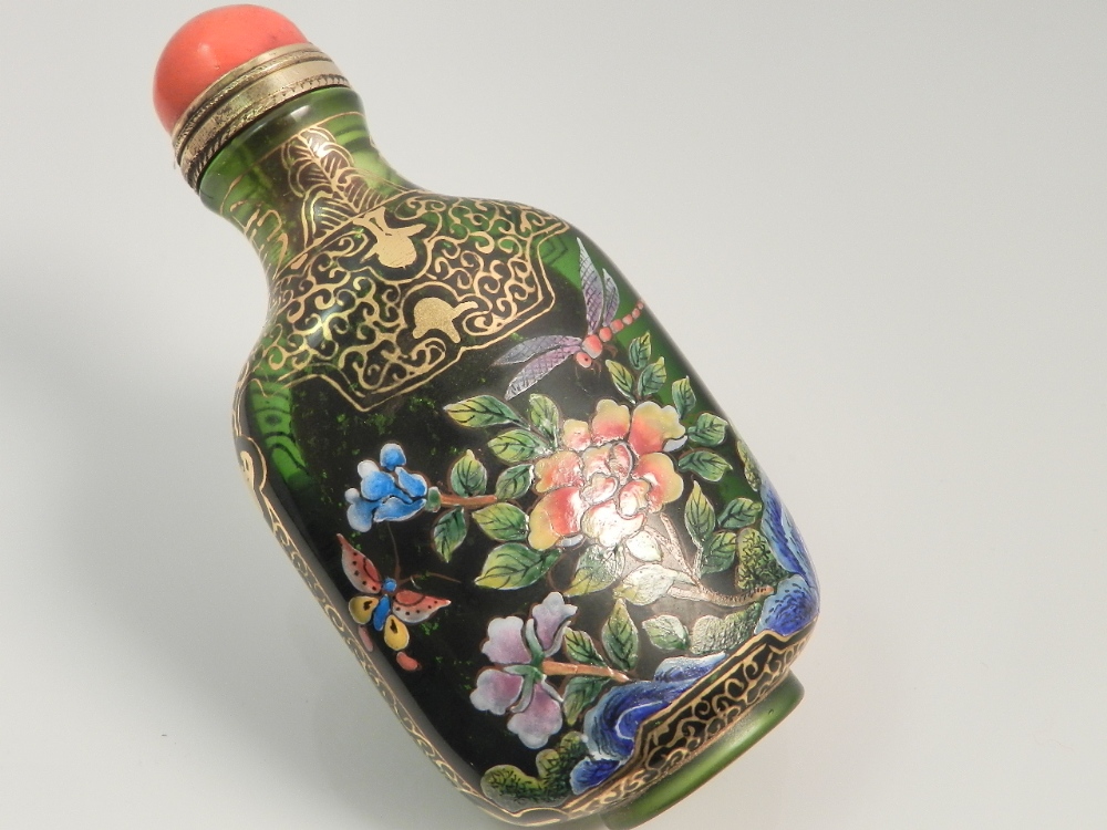 A Chinese green glass scent bottle enamel decorated with flora and fauna.