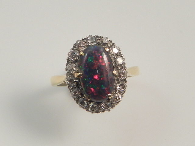 A vintage black opal and old cut diamond cluster ring set on a platinum and 18ct gold band.