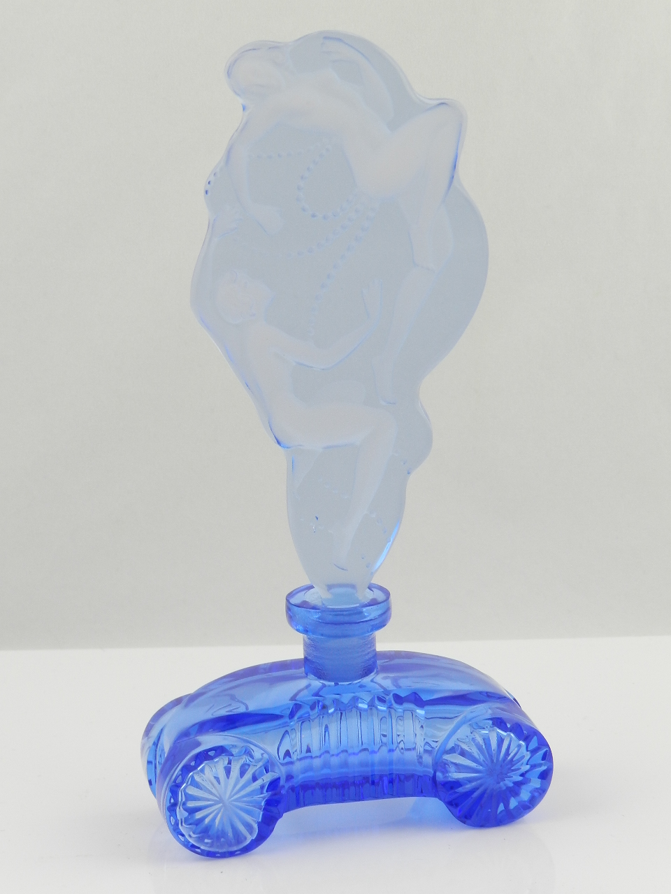 An art deco blue grass scent bottle in the form of two naked figures emerging from a stylized blue