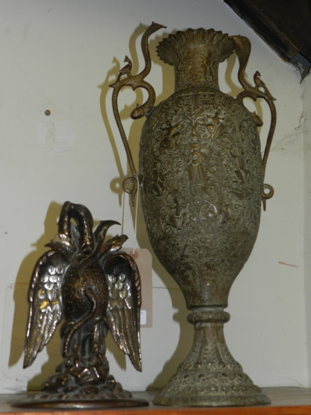 A large intricately tooled brass vase, along with a 19th century doorstop.