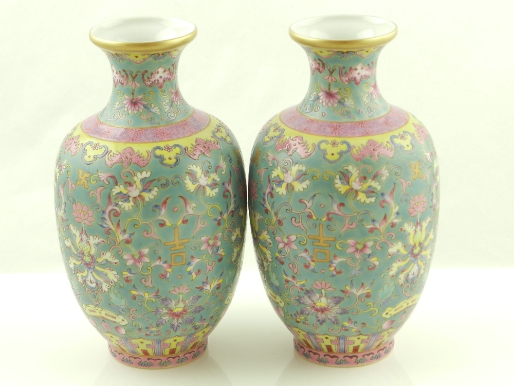 A pair of Chinese porcelain vases enamel decorated with floral designs and character on a green