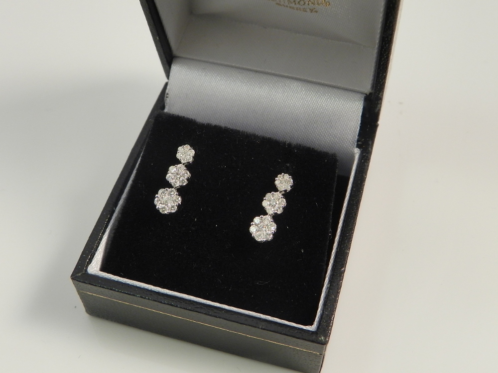 A pair of ladies 18ct white gold mounted diamond cluster earrings of trilogy design