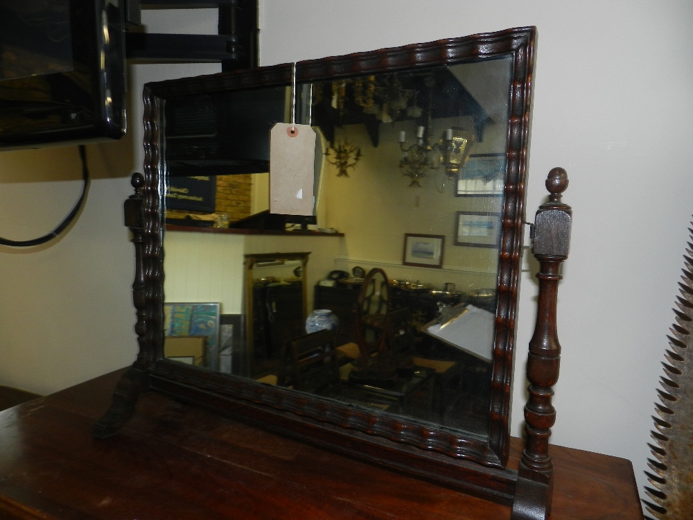 An early 20th century oak swing framed toilet mirror.