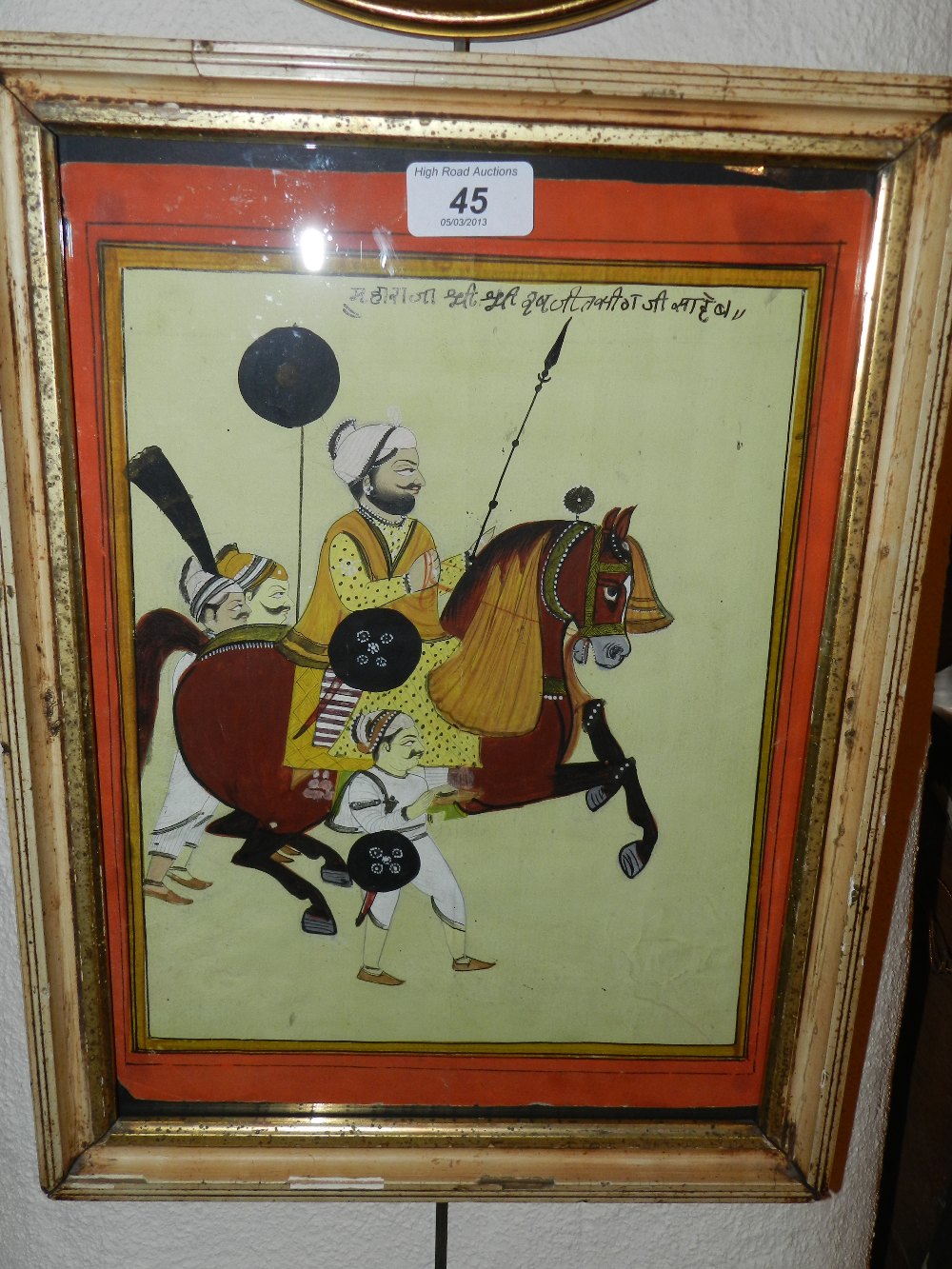 An Indian watercolour of a warrior on horseback with attendant soldiers all in a moulded frame.