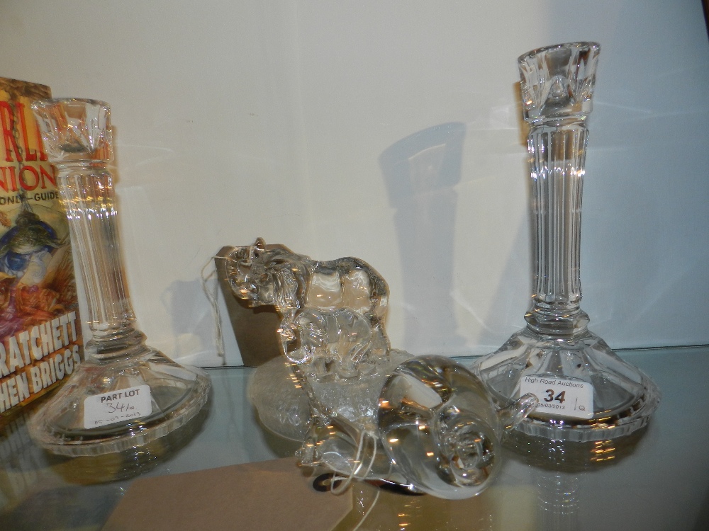 A pair of clear glass table candlesticks of fluted columnular form on raised faceted circular bases,