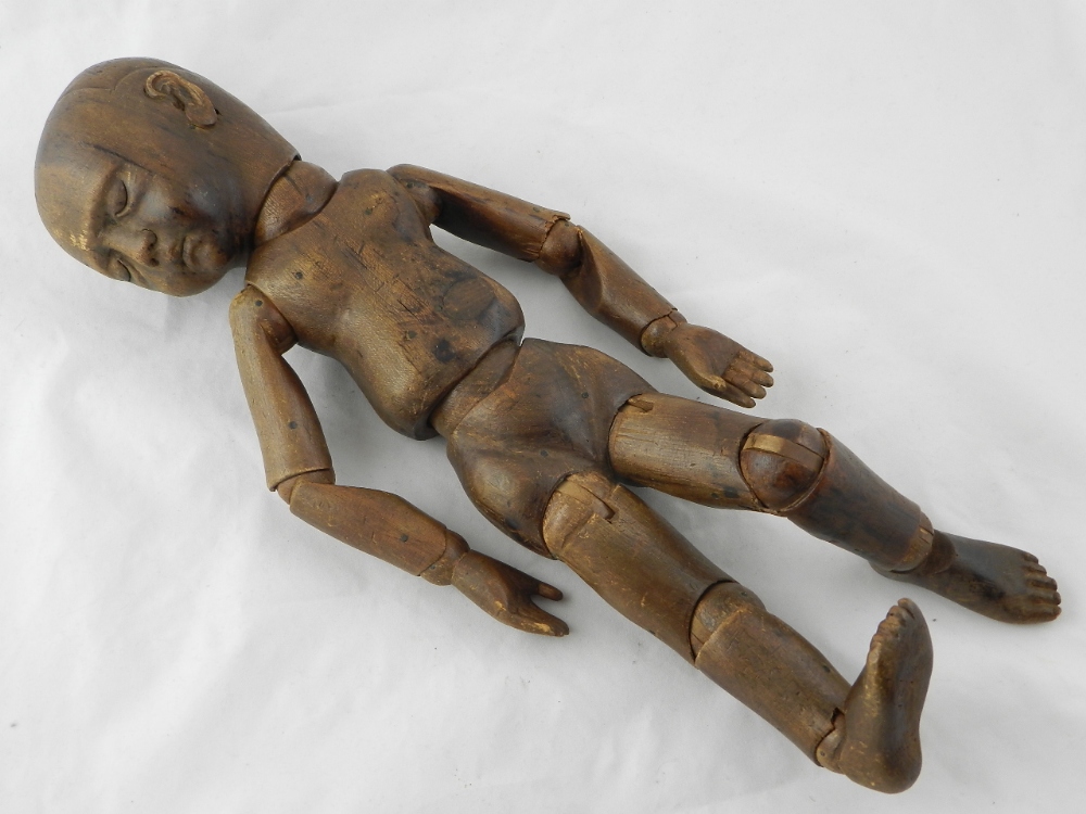 An articulated wooden medical doll - used to study the positions of a fetus.