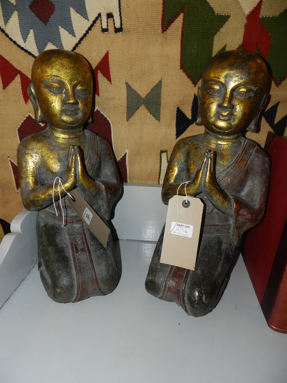 A pair of Chinese part gilt cast iron seated Buddhas.