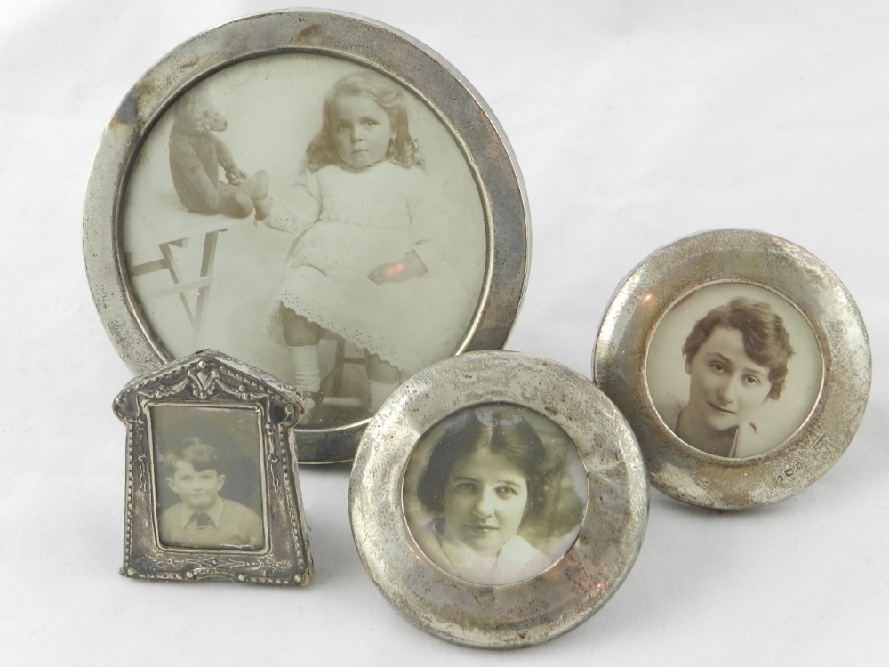 A collection of four miniature sterling silver photo frames