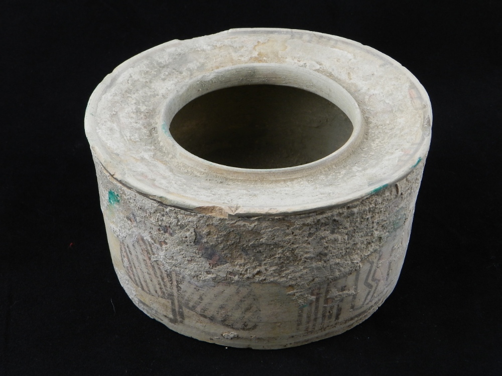 An antique middle eastern earthenware pot, the sides decorated with primitive geometric designs