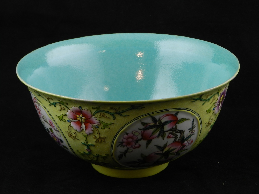 A Chinese ceramic bowl, the yellow ground decorated with raised floral clusters and panels of