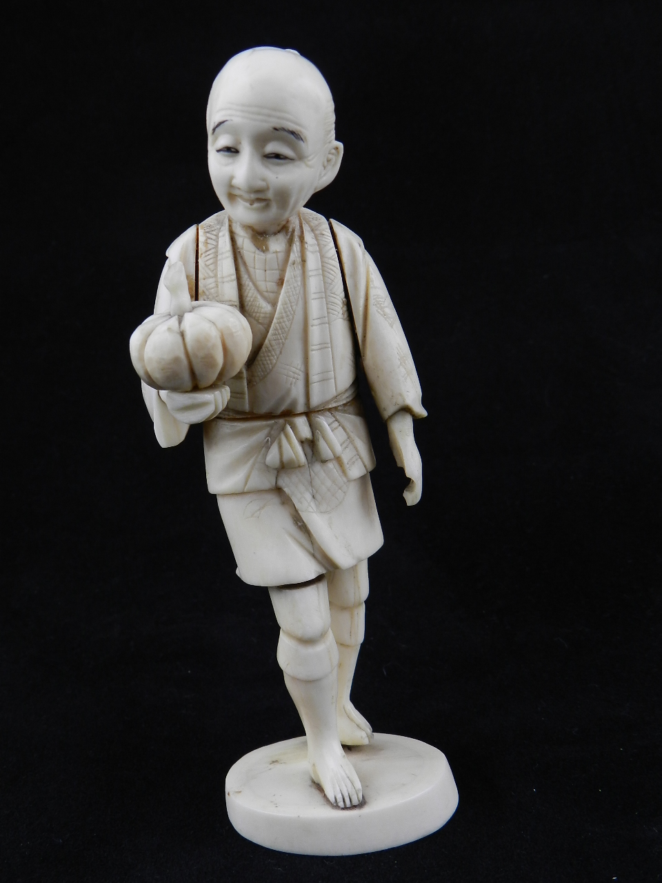 A 1900`s oriental ivory carving of a farmer holding a squash