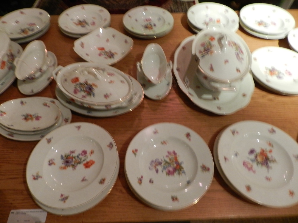 A Czechoslovakian dinner service decorated with flowers and gilt banding to include gravy boats,