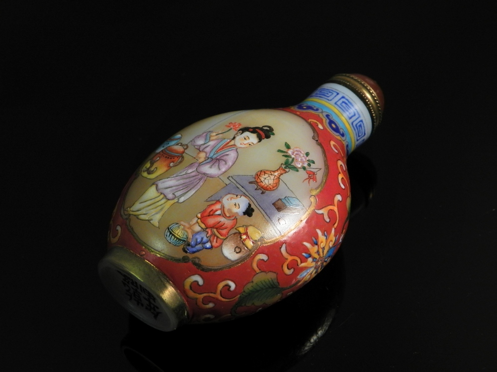 A Chinese 20th century compressed oval scent bottle decorated with women and children within oval