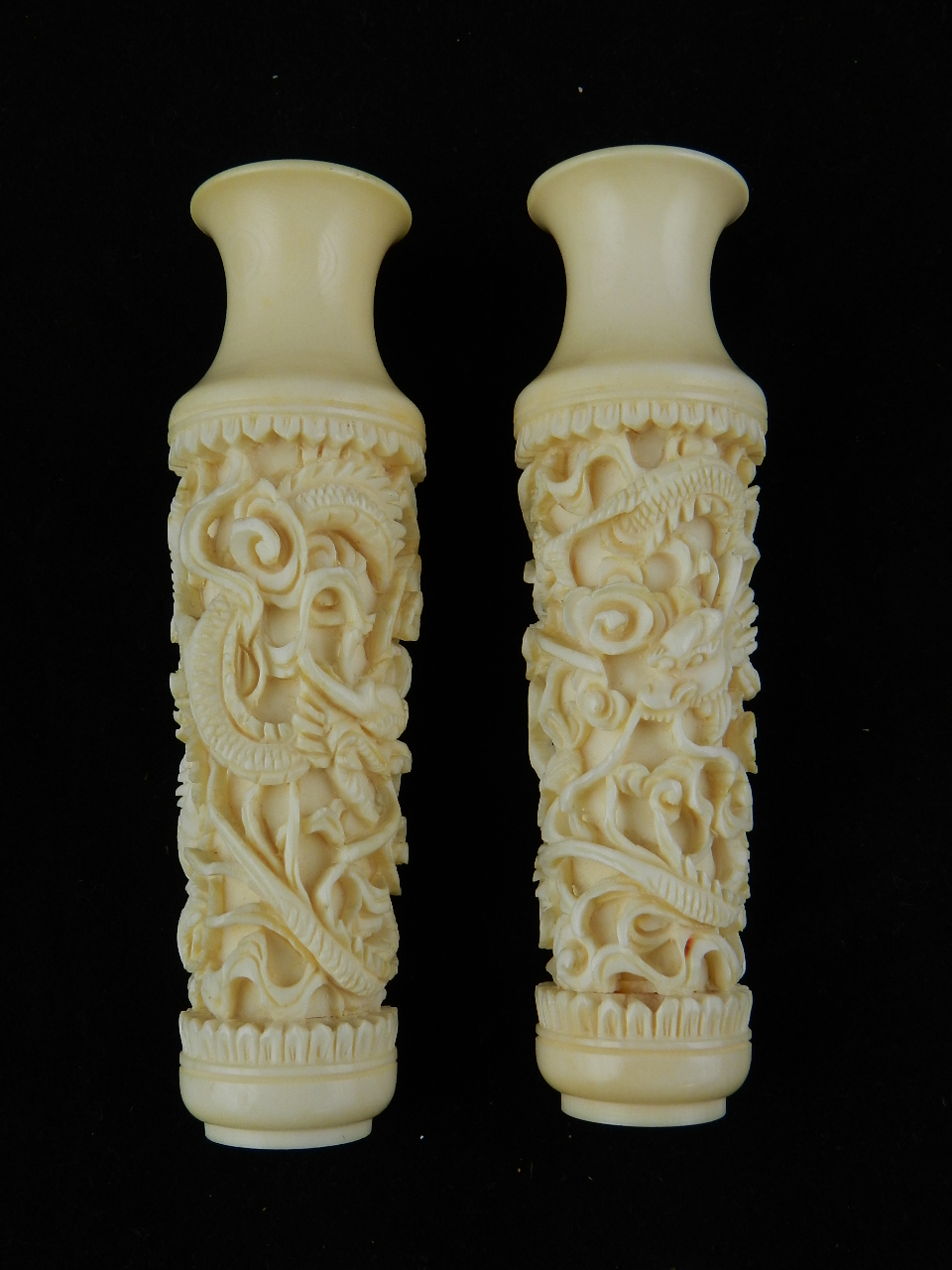 A pair of Chinese ivory vases deeply carved with entwined dragons
