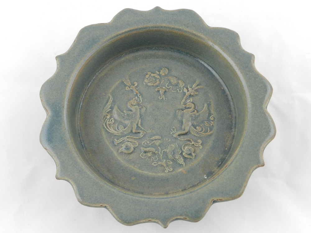 A Chinese ceramic dish with scalloped edge, the centre decorated with mythological birds, leaves and