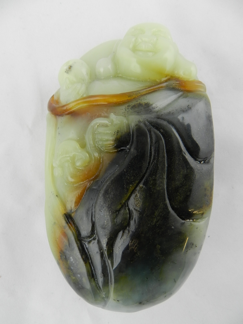 A Chinese natural coloured jade carved with a laughing Buddha
