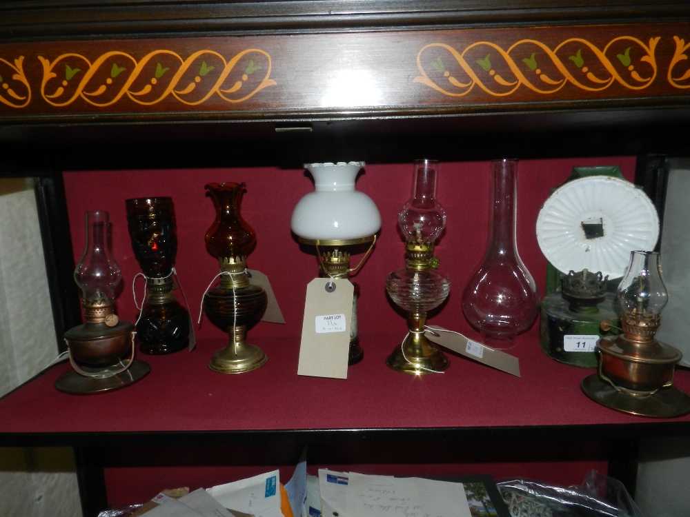 Seven various oil lamps to include a pair of copper lamps with loop handles and a toll ware lamp.