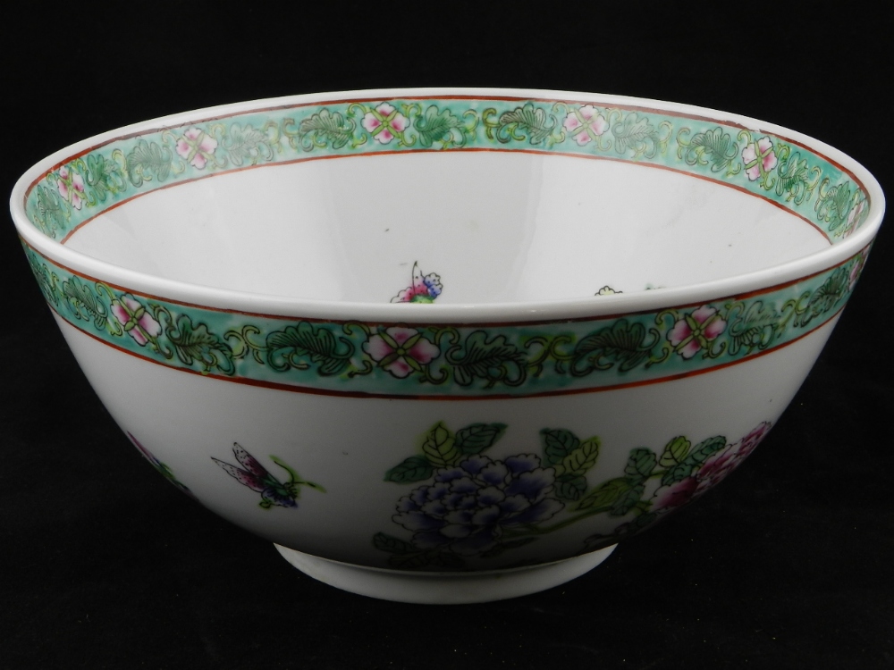 A 20th century famille rose bowl decorated with flowers and butterflies.